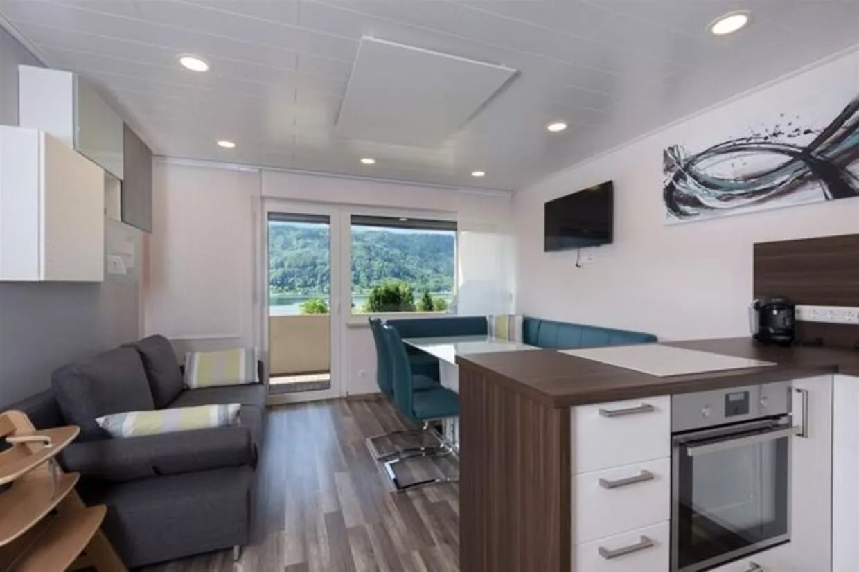 Eine offene Küche und ein Wohnbereich in einer kleinen Wohnung, modern und gemütlich eingerichtet.